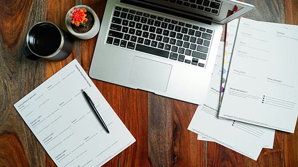 Computer next to paperwork
